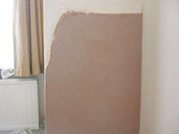 The Raynes Park Plasterer plaster repair to a lounge wall affected with damp in SW20